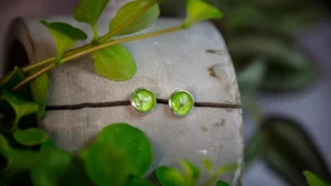 Eine zarte weiße Blüte eingebettet in Epoxidharz und in Edelstahl eingefasst, ergeben einen Traumohrring.