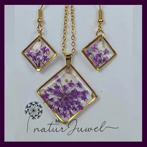 Ein hochwertiges Schmuckset bestehend aus einer Halskette und Ohrringen in lila Farbe mit eingebetteten echten getrockneten Blüten.