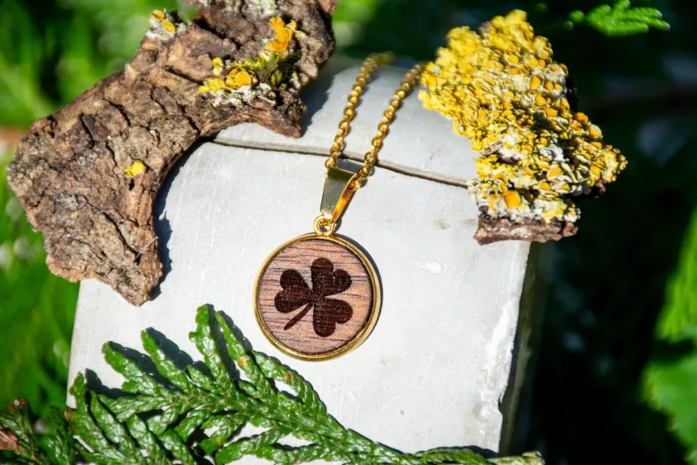 Runder Anhänger aus Walnussholz mit Kleeblattmotiv, handgefertigter Schmuck mit goldfarbener Edelstahlfassung