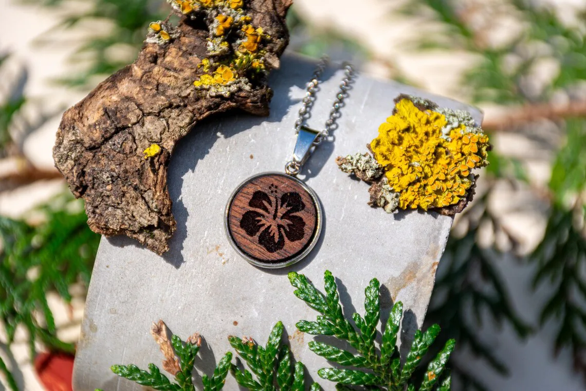 Runder Holzanhänger mit Lotusmotiv, handgefertigter Schmuck aus Walnussholz in silberfarbener Edelstahlfassung