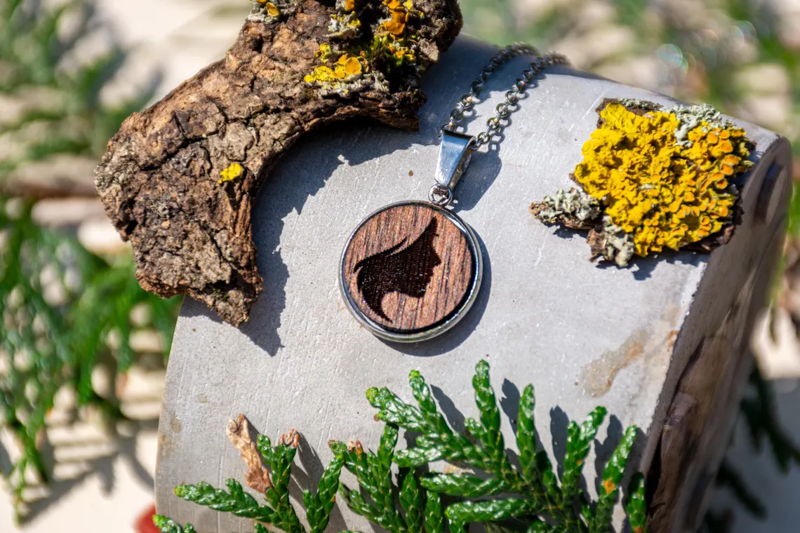 Holzanhänger mit Frauensilhouette, rund, handgefertigt mit Edelstahlrahmen.