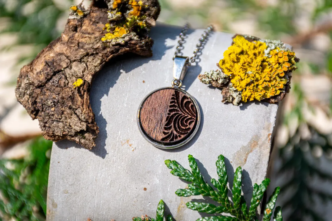 Ornament-Anhänger aus Holz, rund, handgefertigt mit feinen Linien.