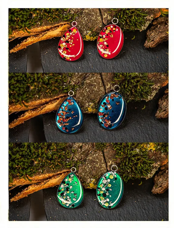 Handgemachter Kettenanhänger aus Harz, handgetupft in Rot, Blau und Grün, Tropfenform vor Naturhintergrund