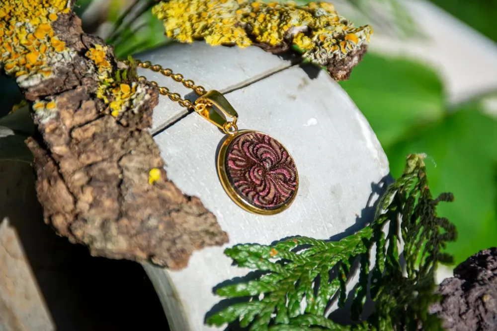 Runder Holzanhänger mit Ornament in Gold und Pink, handgefertigter Schmuck aus Walnussholz