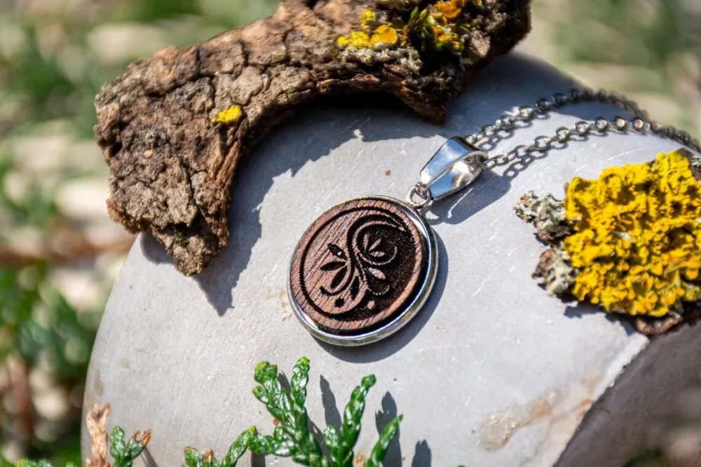 Runder Anhänger mit floralem Muster, handgefertigter Holzschmuck mit Edelstahlfassung