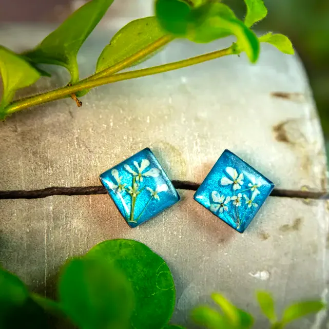 Blaue Ohrstecker mit weißen Blüten – handgefertigter Schmuck mit floraler Eleganz.