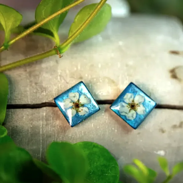 Himmelblaue Ohrstecker mit echten Blüten – handgefertigter Naturschmuck aus Epoxidharz.