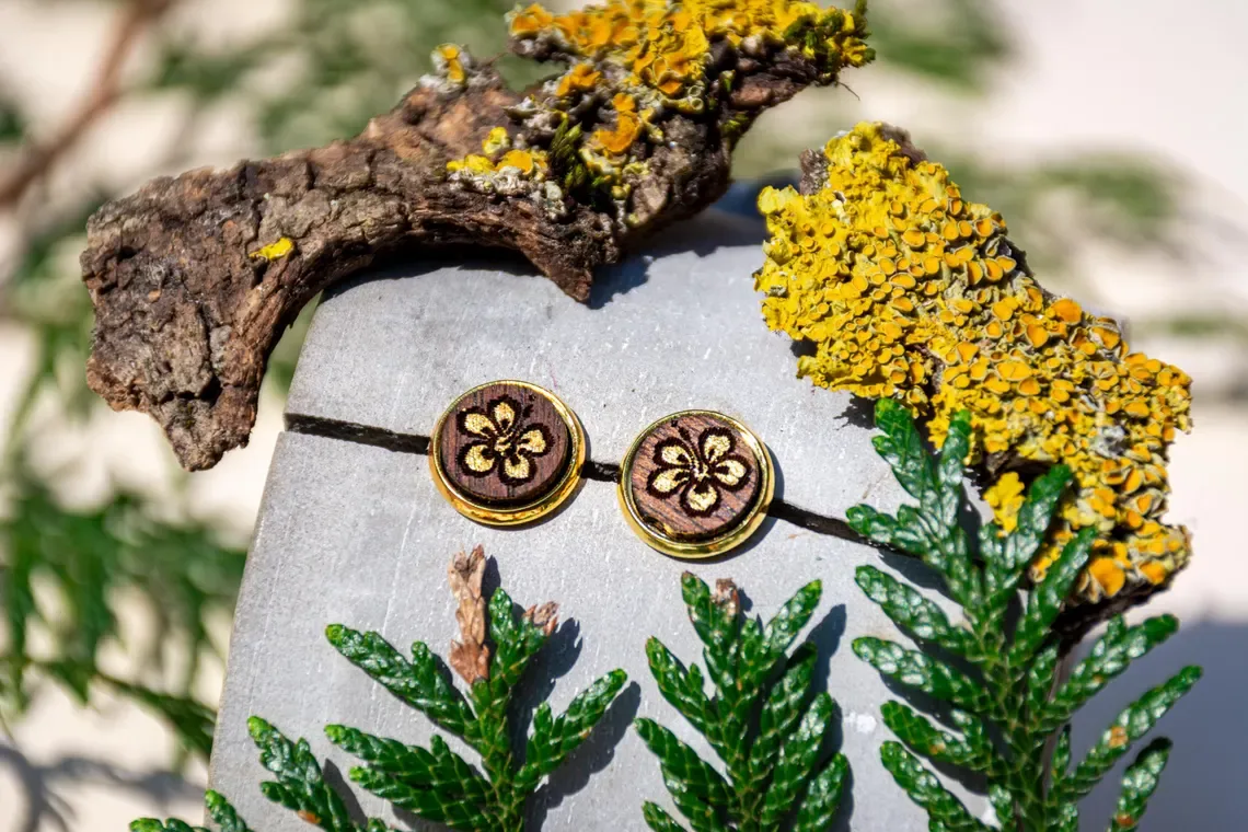 Ohrstecker aus Walnussholz mit Hibiskusmotiv, goldfarbene Edelstahlfassung, handgefertigt.