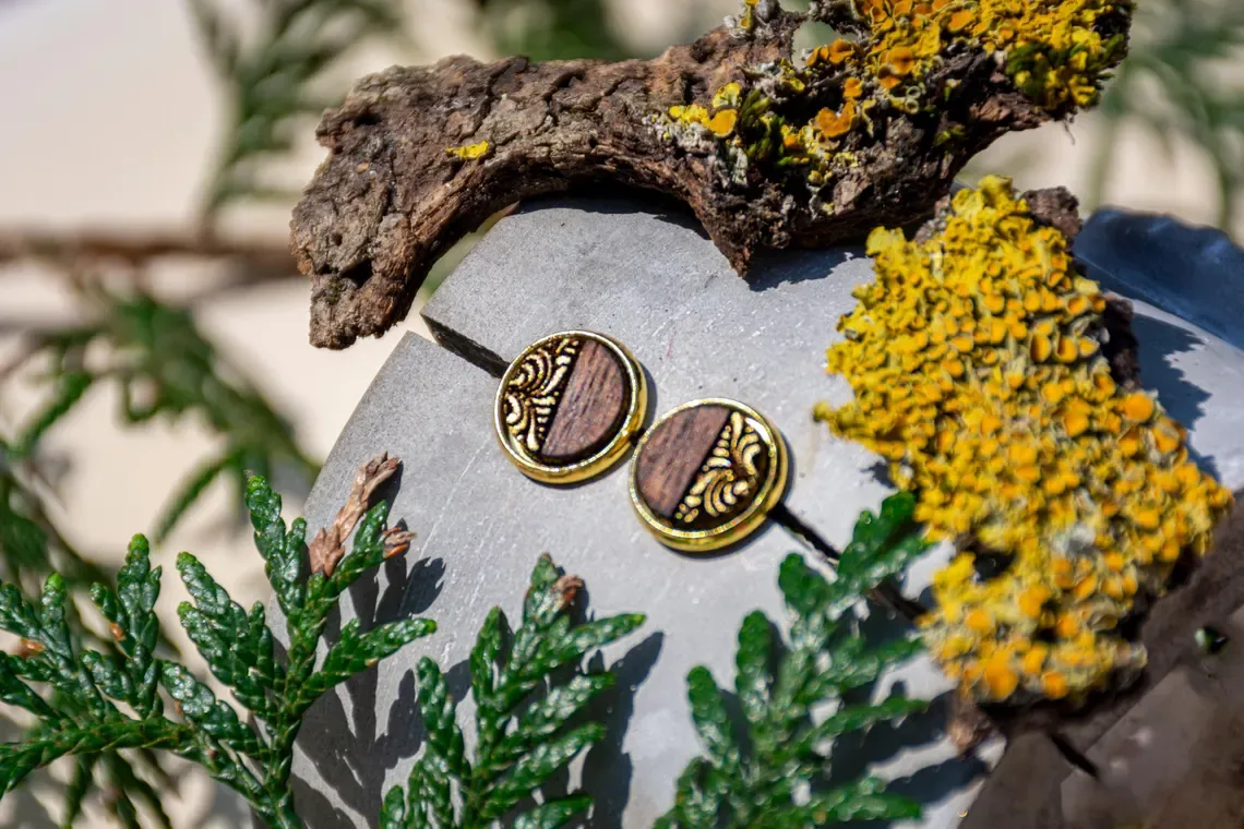 Ohrstecker aus Walnussholz mit feinem Ornamentmuster, goldfarbene Edelstahlfassung, handgefertigt.